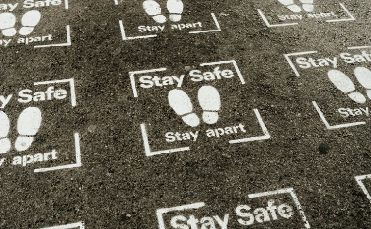 six-foot social distancing feet on flooring